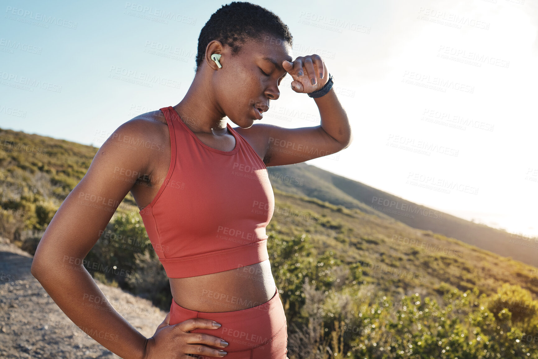 Buy stock photo Fitness, music and tired with a sports black woman running in the mountain for cardio or endurance exercise. Workout, exhausted and sweat with a young female runner or athlete taking a break