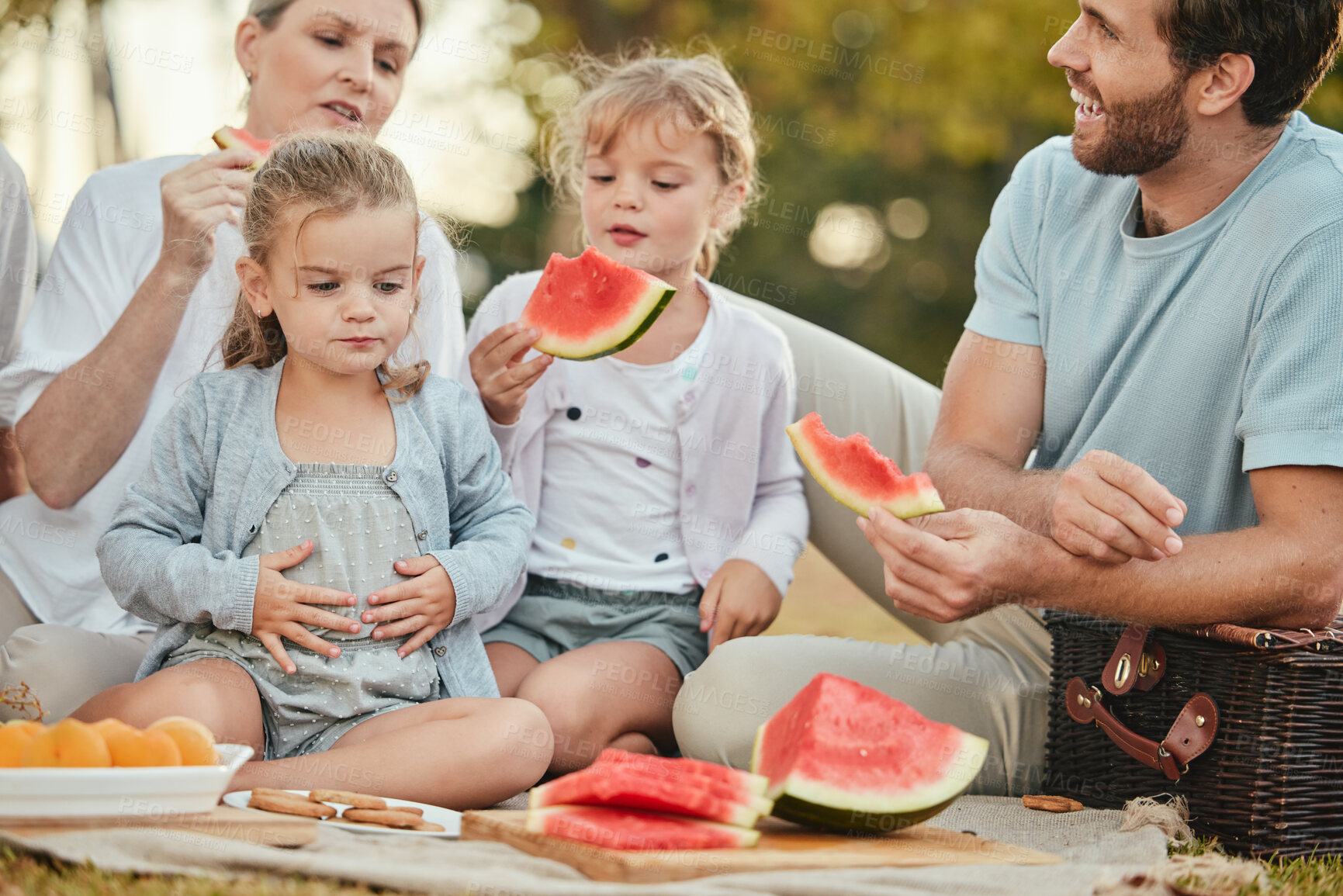 Buy stock photo Park, picnic and couple with children and fruit on blanket in garden for happy summer family time together. Nature, love and relax eating lunch on grass with parents and kids with smile on holiday.