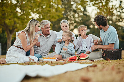 Buy stock photo Happy family, park picnic and summer with fruit, eating and love in nature, holiday and bonding in spring. Big family, healthy watermelon and kids with mom, dad and grandparents on lawn in Melbourne