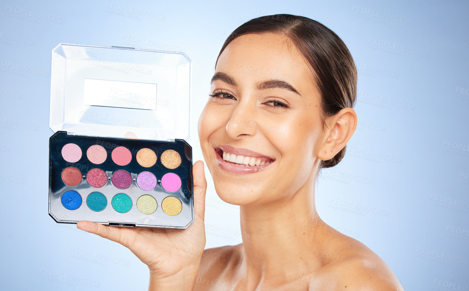 Buy stock photo Beauty, makeup and eye shadow pallet with a model woman in studio on a blue background to apply color. Portrait, face and cosmetics with an attractive young female posing to promote a skin product