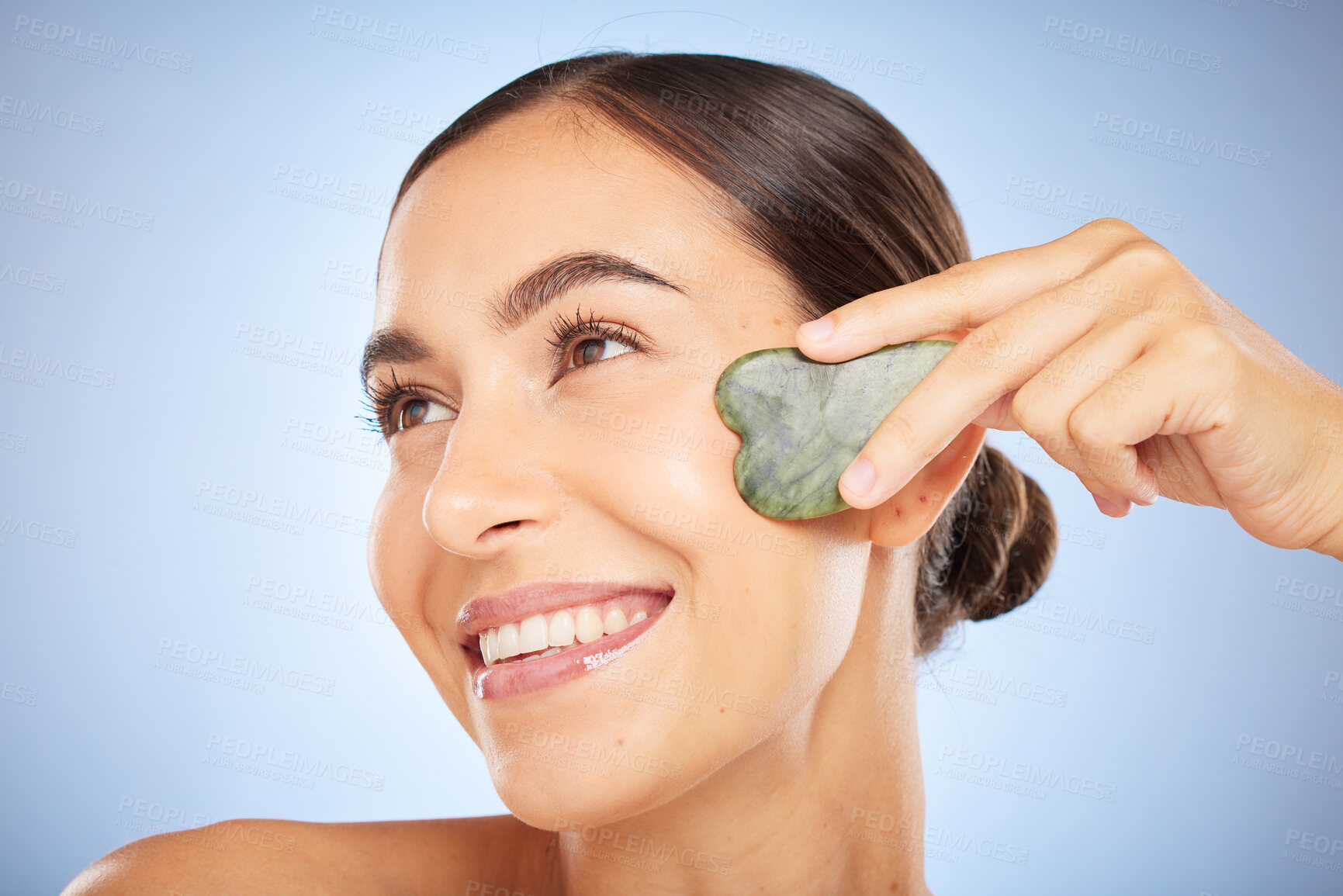 Buy stock photo Skincare, beauty and woman with gua sha in studio on blue background for wellness, healthy skin and glow. Dermatology, spa aesthetic and girl with stone for facial treatment, cosmetics and exfoliate