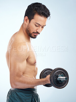 Buy stock photo Man, fitness and dumbbell in studio for muscle, wellness and self care by blue background with focus. Model, bodybuilder workout and training for health, body or development with exercise by backdrop