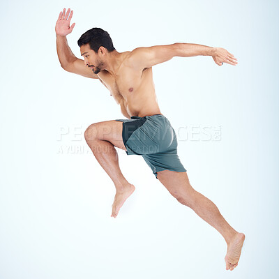Buy stock photo Running, jump and fitness of man in studio isolated on a blue background mock up. Sports, training and male model, athlete or runner jumping, sprint workout and exercising for health and wellness.