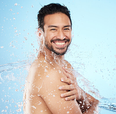 Buy stock photo Portrait, water and shower with a man model in studio on a blue background for hygiene or hydration. Face, beauty and skincare with a handsome young male wet from a water splash in the bathroom