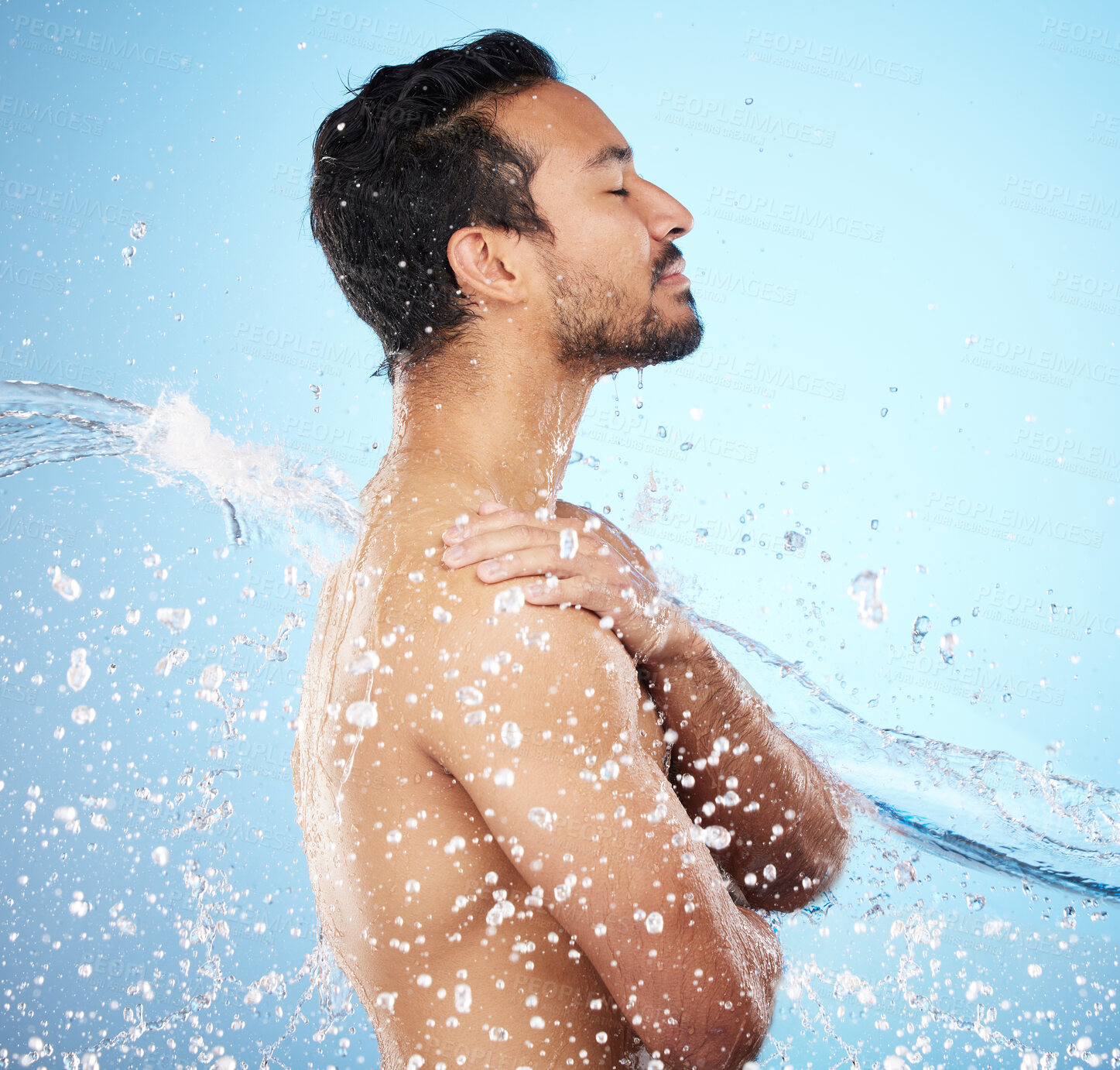 Buy stock photo Man, water splash and clean for skincare, wellness and health with beauty, grooming and on blue studio background. Cleaning, male and shower for washing, organic care and hygiene for natural skin.