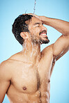 Face, water splash and man in shower cleaning for body care in studio isolated on a blue background. Hygiene, skincare and profile of male model bathing and washing for health, wellness and beauty.