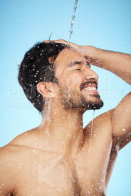 Buy stock photo Face, water splash and man in shower cleaning for body care in studio isolated on a blue background. Hygiene, skincare and profile of male model bathing and washing for health, wellness and beauty.