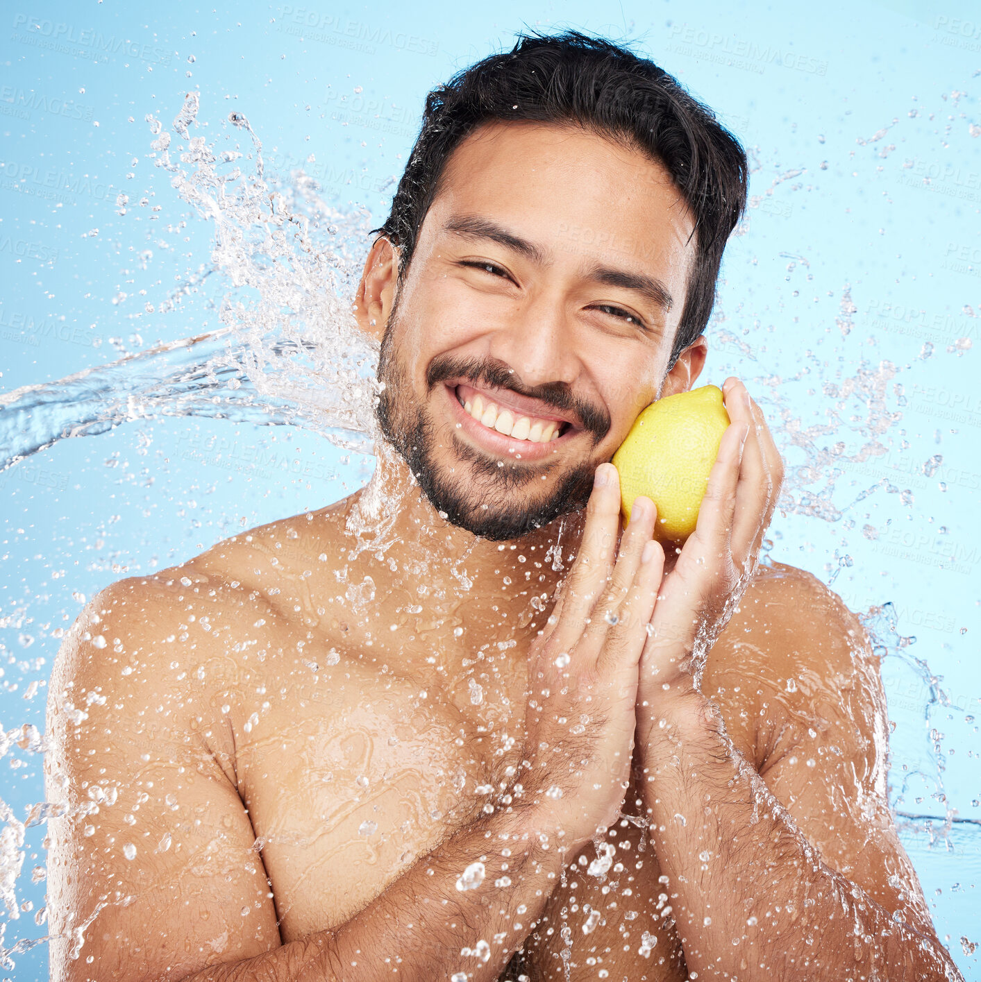 Buy stock photo Skincare, water and portrait of man with a lemon in studio for healthy, organic and natural face routine. Health, wellness and man from India with citrus fruit for facial treatment by blue background