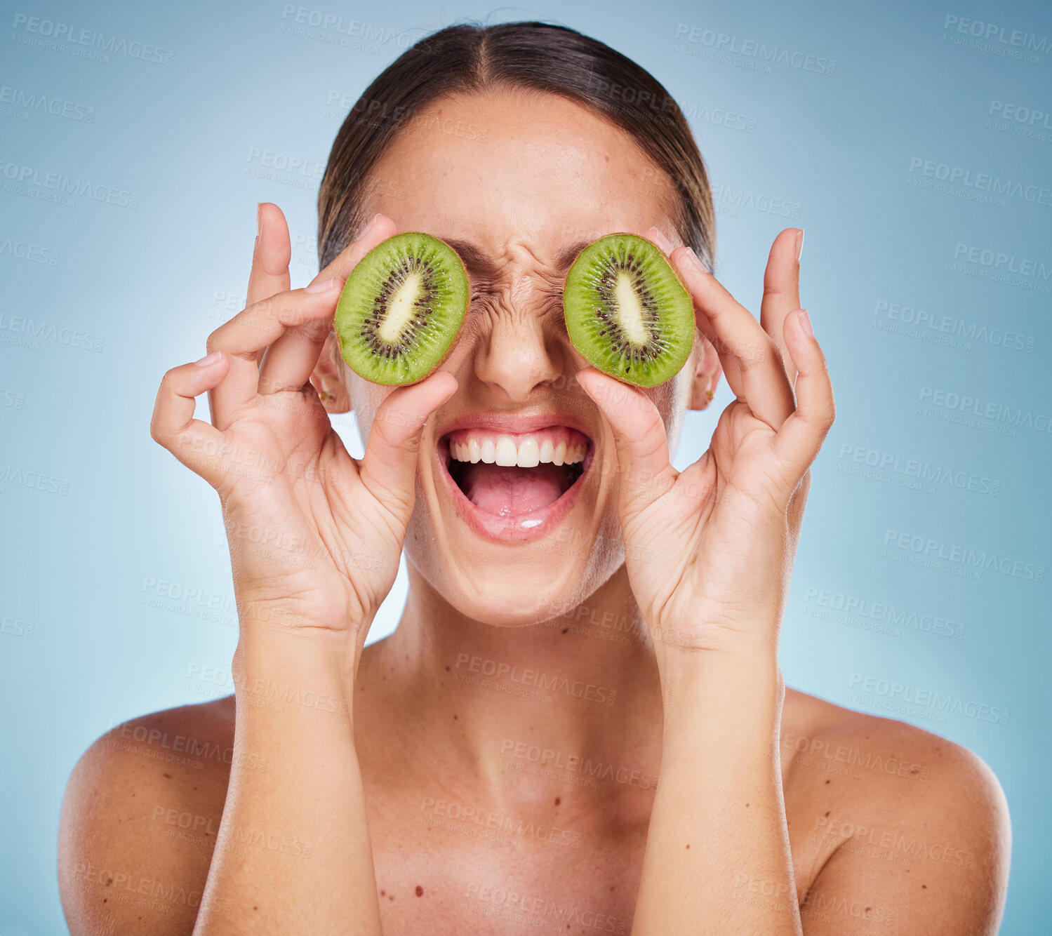 Buy stock photo Beauty, kiwi and face, woman and skincare with natural glow from organic and vegan cosmetics for facial treatment Healthy skin, exotic fruit product and happy, wellness with blue studio background.