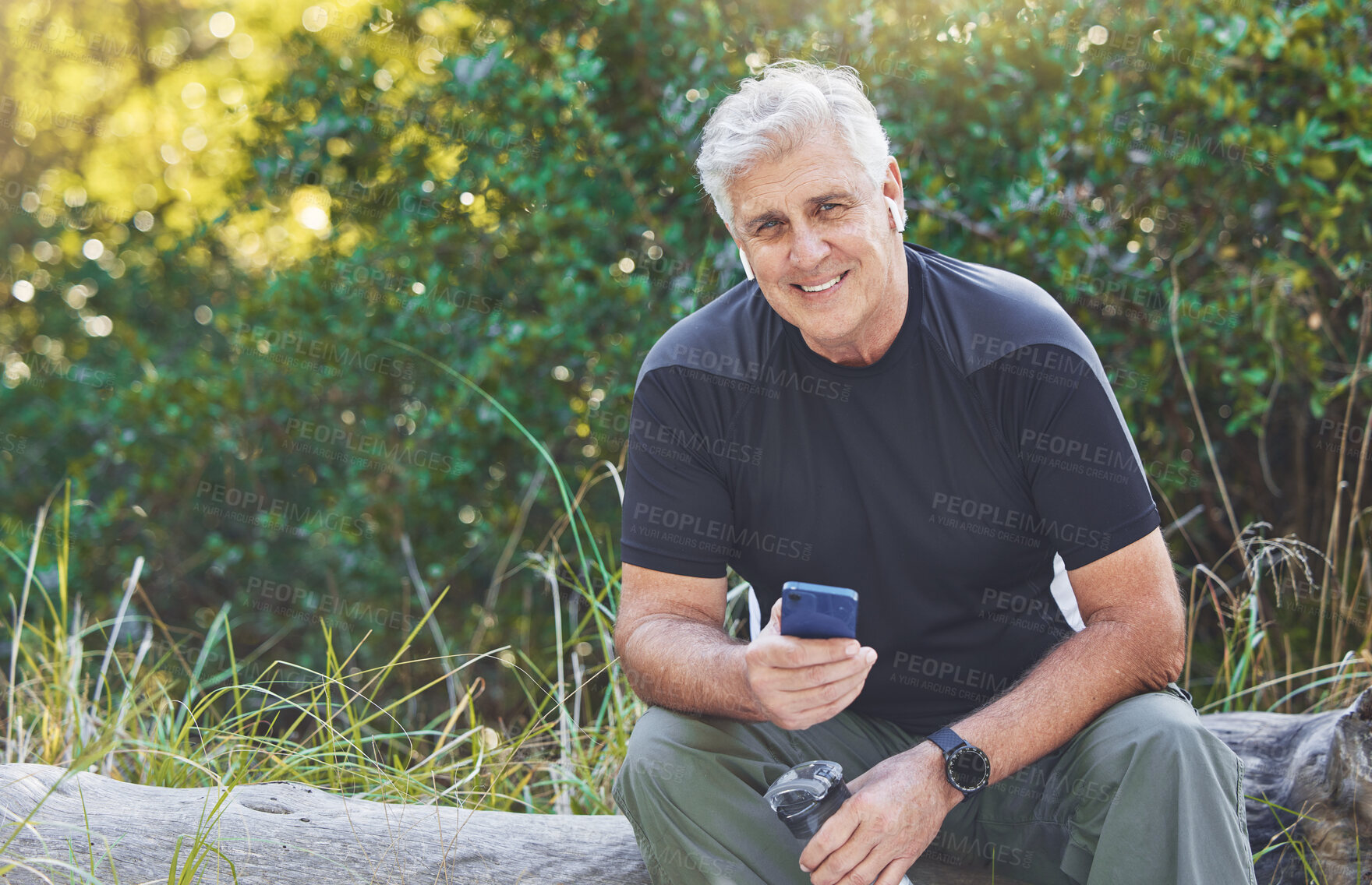 Buy stock photo Senior runner man, music and rest in nature portrait, smile or smartphone for workout, exercise or health. Happy elderly guy, phone and streaming audio on app, web and sitting in forest for fitness