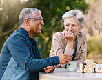 Happy, chess or couple of friends in nature playing a board game, bonding or talking about a funny story. Park, support or healthy senior people laughing at a joke and enjoying quality relaxing time 