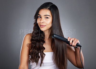 Portrait, woman and hair straightener for care, natural beauty or treatment  on grey studio background. Female, girl and salon equipment for luxury,  ironing hair style and grooming routine for styling | Buy