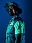 Fashion, trendy and black man model in a studio with a cool, stylish and casual outfit with lighting. Edgy, style and modern fashionable African male posing while isolated by a blue background.
