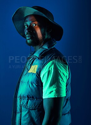 Buy stock photo Fashion, trendy and black man model in a studio with a cool, stylish and casual outfit with lighting. Edgy, style and modern fashionable African male posing while isolated by a blue background.