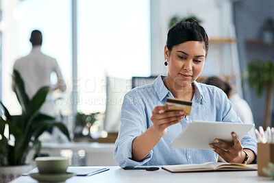 Buy stock photo Shot of a young businesswoman using a digital tablet and credit card in an office