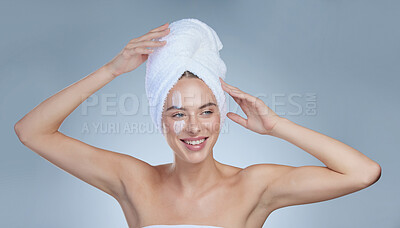 Buy stock photo Studio shot of an attractive young woman posing with a towel on her head against a grey background