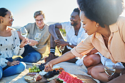Friends, travel and picnic with food and outdoor in nature, fruit and cheese for nutrition and adventure in park. Wine, sun and summer holiday with social group, diversity and young people together.