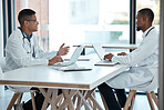 Healthcare, strategy and planning, doctors in meeting with laptop and discussion at table in hospital meeting room. Teamwork, collaboration and innovation in medical research, men talking in clinic.