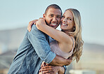 Interracial, happy couple and smile portrait hug of people in summer with happiness and love. Couple, outdoor and happiness of marriage, care and vacation gratitude in sunshine together feeling calm