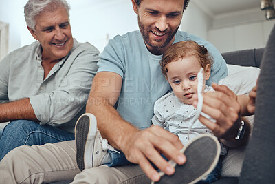 Buy stock photo Family, love and dad with child on sofa to tie shoes laces enjoying weekend, quality time and bonding together. Family home, support and grandfather, father and boy relaxing on couch in living room