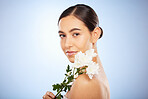 Face portrait, skincare and woman with flower in studio on a blue background mockup. Organic makeup, floral cosmetics and female model with white plant for facial treatment, healthy skin and beauty.