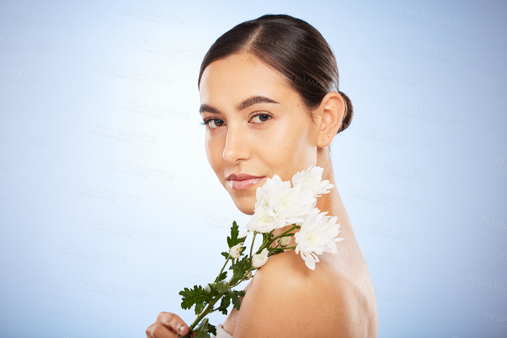 Buy stock photo Face portrait, skincare and woman with flower in studio on a blue background mockup. Organic makeup, floral cosmetics and female model with white plant for facial treatment, healthy skin and beauty.