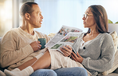 Buy stock photo Senior couple, newspaper and relax talking on sofa reading, morning conversation or quality time bonding together in living room. Elderly man, woman and news discussion, coffee and retirement peace