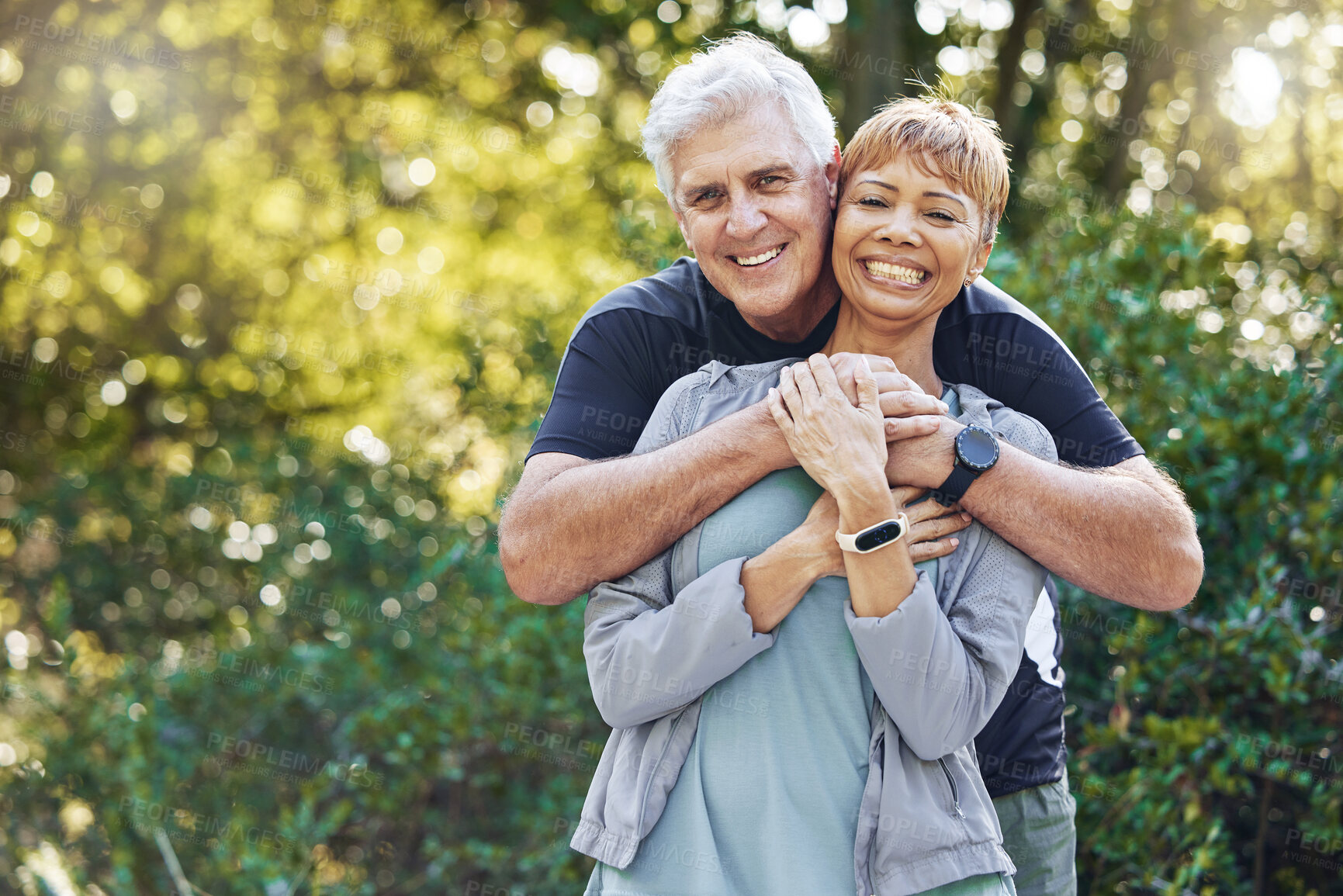 Buy stock photo Nature, love and man hugging his wife with care, happiness and affection while on an outdoor walk. Happy, romance and portrait of a senior couple in retirement embracing in the forest, woods or park.