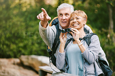 Buy stock photo Elderly, couple hiking and bird watching with adventure outdoor, hike together and fitness for active lifestyle. Nature, trekking and senior man pointing and woman with binocular,  freedom and travel