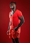 Black man, studio portrait and sport clothes with smile, sunglasses or happiness by red background. Model, man and happy with summer fashion, beauty and sports style for health, self care or wellness