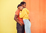 Love, hug and comfort with a black couple together outside on a color wall background for romance or dating. Hugging, date and consoling with a man and woman holding each other in support or care