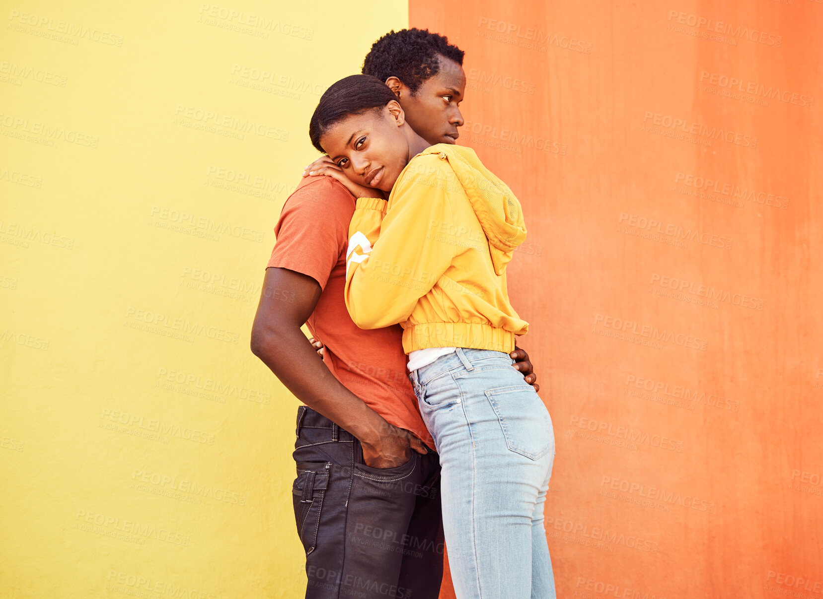Buy stock photo Love, hug and comfort with a black couple together outside on a color wall background for romance or dating. Hugging, date and consoling with a man and woman holding each other in support or care