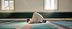 Mosque, worship and muslim man in prayer on his knees for gratitude, support or ramadan for spiritual wellness. Religion, tradition and islamic guy praying or reciting quran to allah at islam temple.