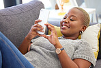 Social media, relax and black woman with a phone for communication, mobile chat and app on the sofa. Connection, internet and calm African girl with a mobile for online conversation on the couch