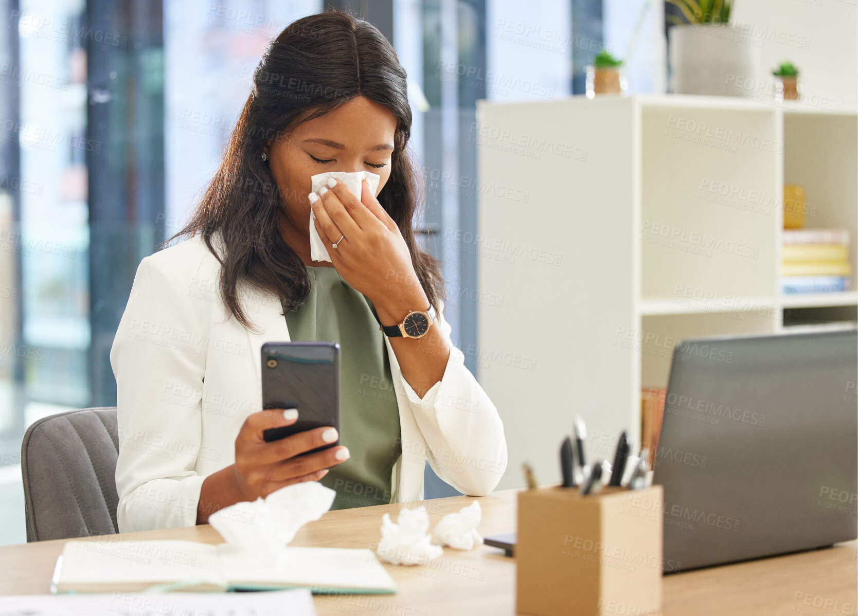 Buy stock photo Business woman, tissue and allergy while using phone and blowing nose while sick with covid or flu virus at corporate desk. Black female entrepreneur with communication app for a health consultation