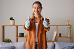 Happy woman, thumbs up and cleaning service with a smile in a house or apartment living room for safety with gloves. Female cleaner showing hand sign to clean dirt, dust and bacteria at home