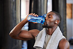 Drinking water, fitness and gym with a black man athlete taking a break from his exercise or workout routine. Training, health and wellness with a sporty male having a drink for hydration or recovery