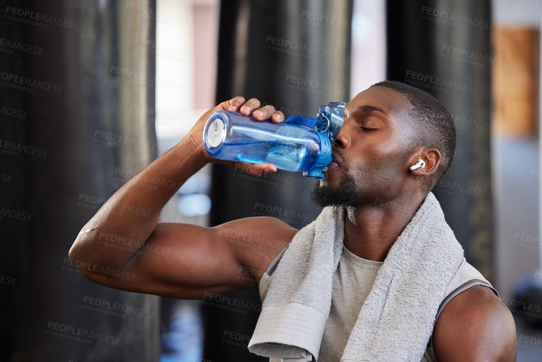 Buy stock photo Drinking water, fitness and gym with a black man athlete taking a break from his exercise or workout routine. Training, health and wellness with a sporty male having a drink for hydration or recovery