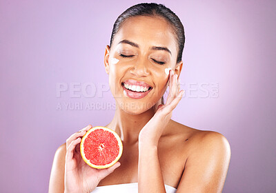 Buy stock photo Woman, face skincare or grapefruit cream on purple studio background in organic dermatology, healthcare sunscreen wellness or self care grooming. Smile, happy or beauty model and fruit facial product