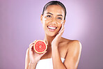 Woman, face skincare or grapefruit product on purple studio background for organic dermatology, healthcare wellness or self care grooming. Portrait, smile or happy beauty model and fruit facial cream