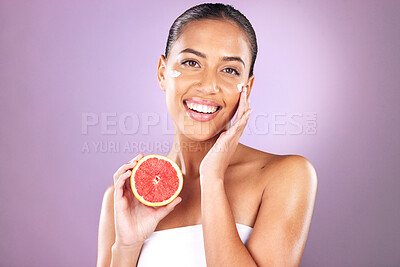 Buy stock photo Woman, face skincare or grapefruit product on purple studio background for organic dermatology, healthcare wellness or self care grooming. Portrait, smile or happy beauty model and fruit facial cream
