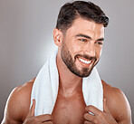 Man with towel, beauty and face with skincare, hygiene and self care against studio background. Grooming, skin and glow with cosmetic, facial wellness and happy male with beard, clean teeth and smile
