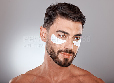 Buy stock photo Skincare, beauty and man with mask for eyes on gray background for wellness, facial treatment and dermatology. Grooming, luxury spa and male with face patch, eye pads and cosmetics products in studio