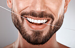 Dentist, floss and mouth of man with smile on gray background in studio for wellness, healthcare and hygiene. Dental care, grooming and zoom of male model for dentistry, cleaning and flossing teeth