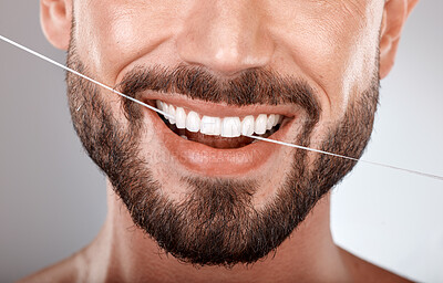 Buy stock photo Dentist, floss and mouth of man with smile on gray background in studio for wellness, healthcare and hygiene. Dental care, grooming and zoom of male model for dentistry, cleaning and flossing teeth