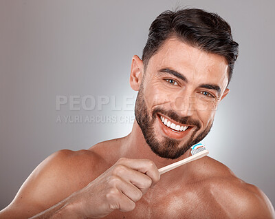 Buy stock photo Portrait, man and brushing teeth with smile, dental hygiene and on grey studio background. Gum care, male and toothbrush for healthcare, toothpaste and fresh breath for oral cleaning and mouth clean
