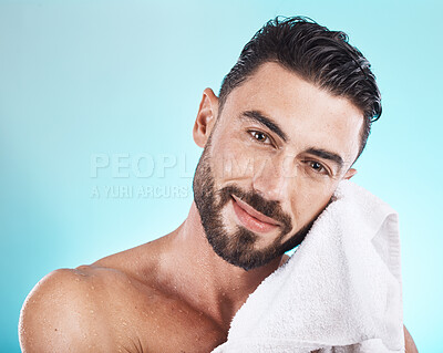 Buy stock photo Man face, towel and skincare while wet after a shower, facial or bath for skincare, hygiene and dermatology on blue. Portrait of happy male model in studio for clean body for health and wellness