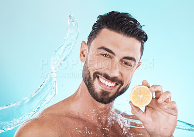 Buy stock photo Beauty, skincare and man with a lemon and water splash for dermatology, facial wellness and nutrition on a blue background in studio. Fruit, diet and face portrait of a model with vitamin c for body