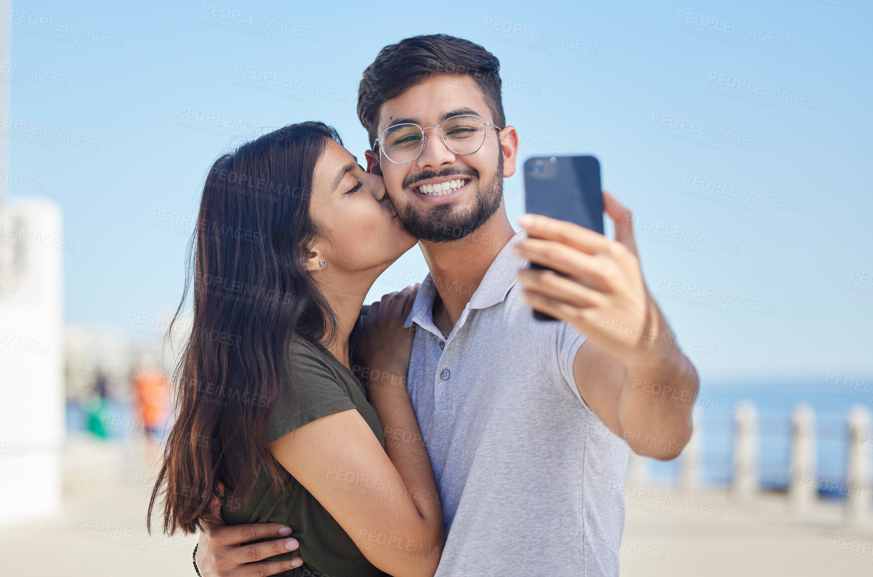 Buy stock photo Phone, kiss or couple love taking a selfie on a romantic honeymoon, beach holiday or vacation in a summer romance. Smile, profile pictures or happy man enjoys quality bonding time with Indian partner