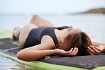 Relax, woman or surfer on water at a beach on holiday vacation resting on a surfboard in Bali. Freedom, thinking or healthy sports girl relaxing body in calm nature, sea or peaceful ocean in summer